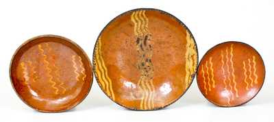 Three Slip-Decorated Redware Plates, Pennsylvania origin, early to mid 19th century