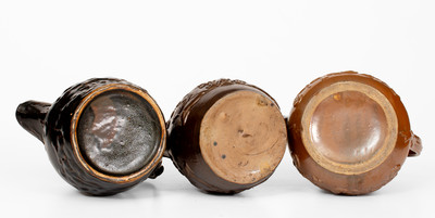 Lot of Three: Unusual Molded Albany Slip-Glazed Stoneware Pitchers