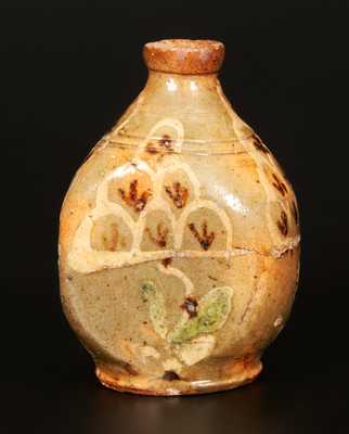 Exceptional Redware Pocket Flask with Three-Color Slip-Decorated Floral Designs