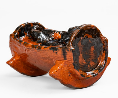 Rare and Important Figural Redware Baby-in-Cradle Bank, probably Pennsylvania