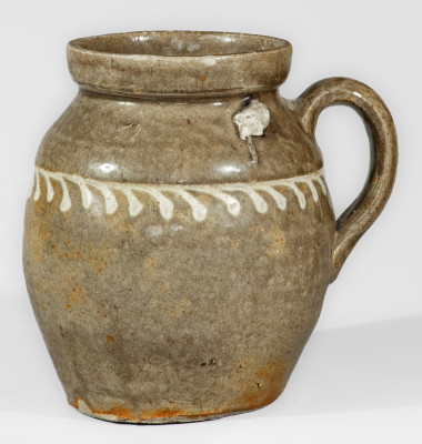 Alkaline-Glazed Stoneware Handled Jar with Kaolin Slip Decoration, attributed to the Collin Rhodes Pottery, Shaw s Creek, Edgefield District, SC, circa 1850.  